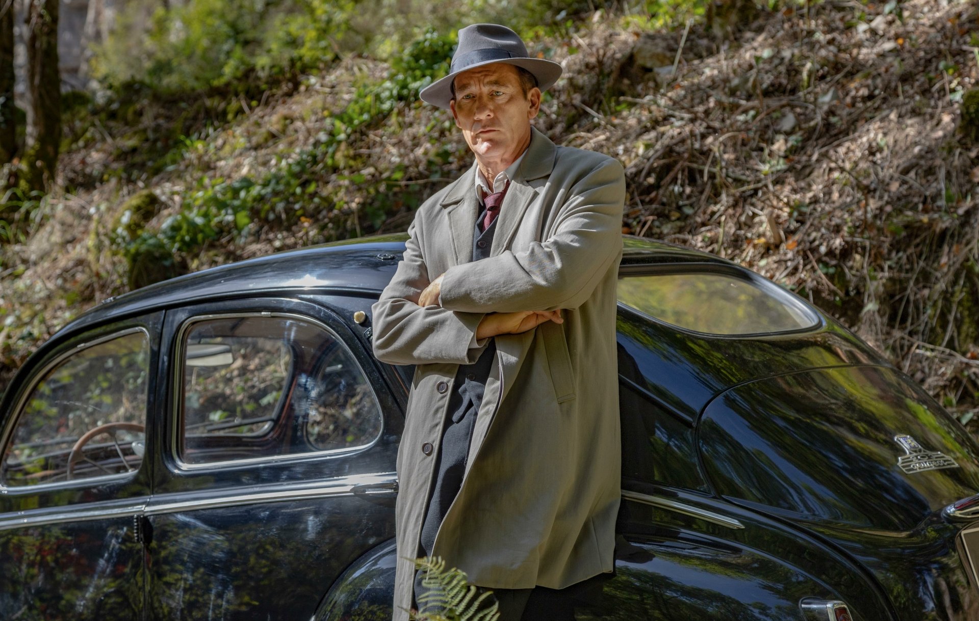 HD wallpaper from Monsieur Spade TV show featuring a character leaning on a vintage car outdoors.