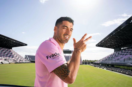 Soccer player in Inter Miami CF jersey posing with a peace sign at the stadium, HD desktop wallpaper and background for sports enthusiasts.