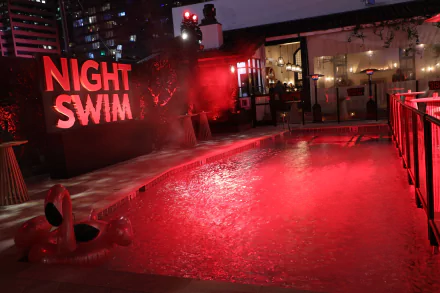 HD desktop wallpaper of a vibrant 'Night Swim' pool scene with illuminated red water and ambient lighting.