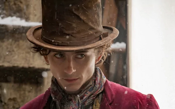 Timothée Chalamet as Willy Wonka in a snowy scene, showcasing a striking expression and intricate costume details. High-definition desktop wallpaper and background inspired by the movie Wonka.