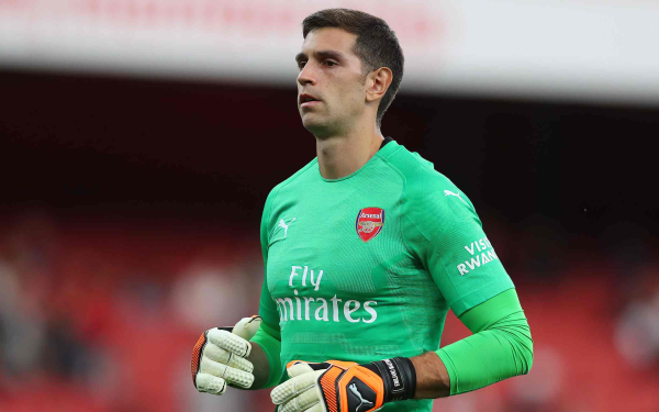 HD wallpaper featuring a goalkeeper in Arsenal F.C. kit, associated with soccer and focused during a game, ideal for desktop background.