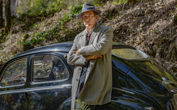 HD wallpaper from Monsieur Spade TV show featuring a character leaning on a vintage car outdoors.