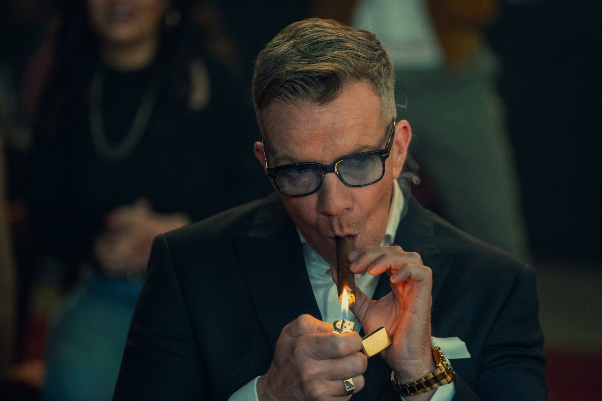 Character from The Gentlemen (2024) TV show lighting a cigar, in a high-definition desktop wallpaper.