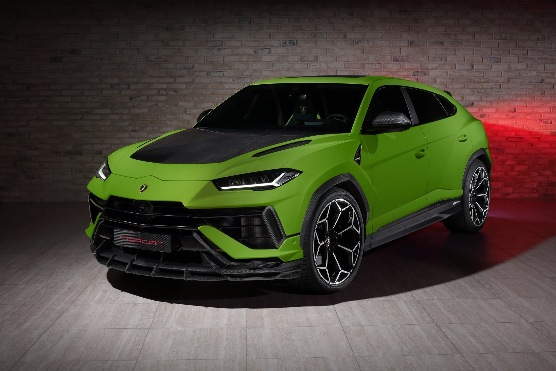 HD desktop wallpaper featuring a green Lamborghini Urus Performante parked in a stylish interior with brick wall background, illuminating luxury and performance.