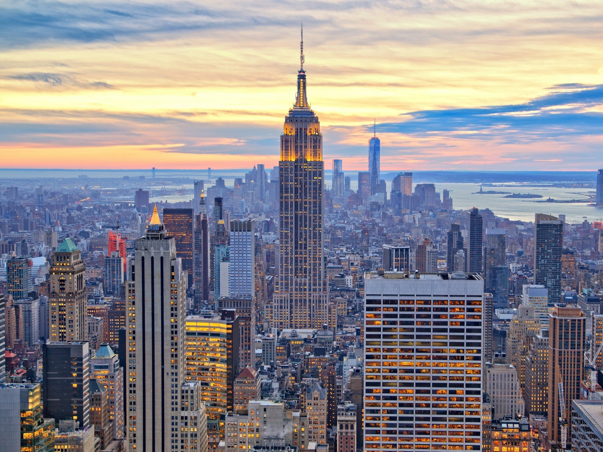 HD desktop wallpaper of the Empire State Building towering over New York City at dusk.