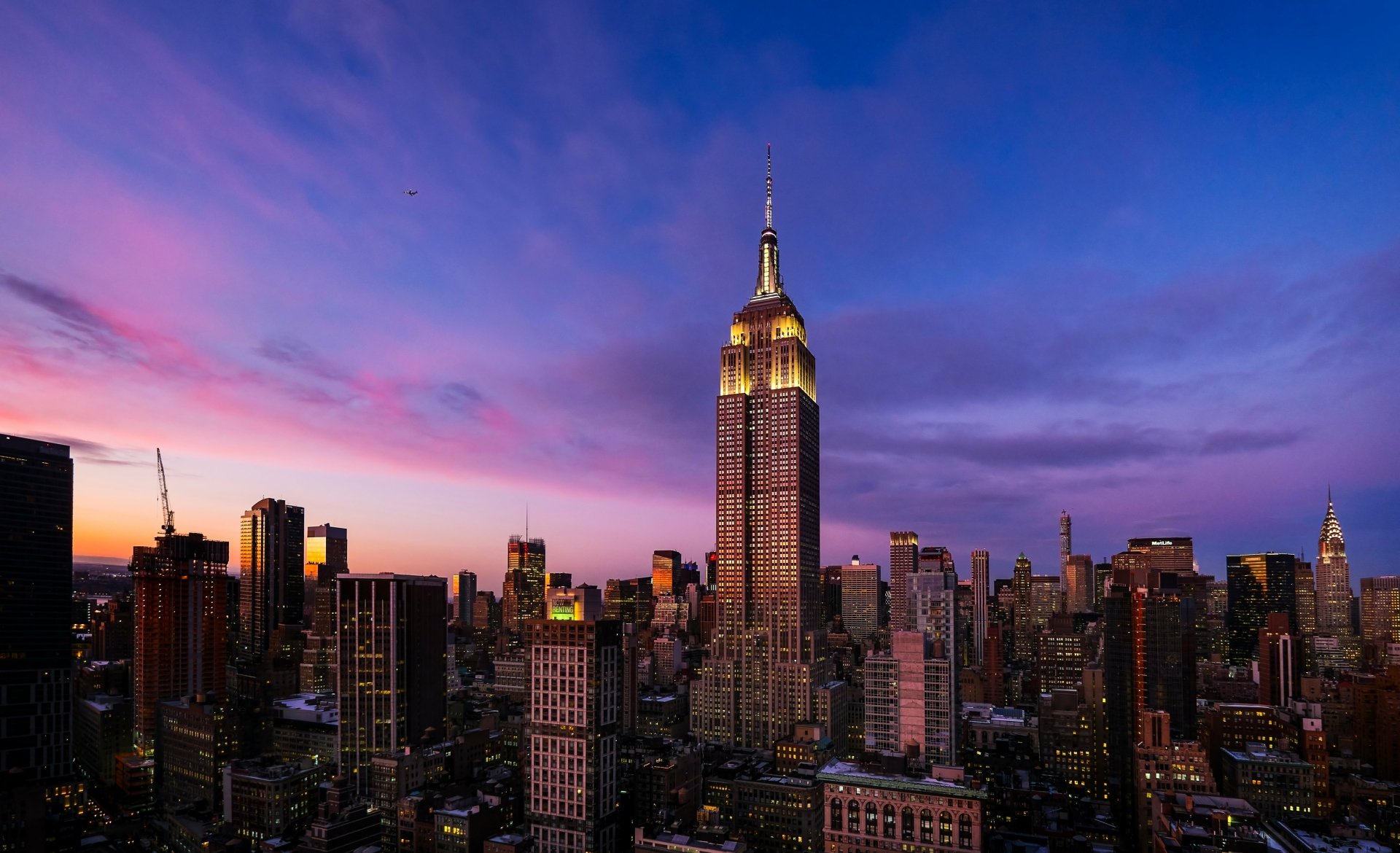 HD wallpaper of the Empire State Building at sunset with panoramic view of New York City skyline.