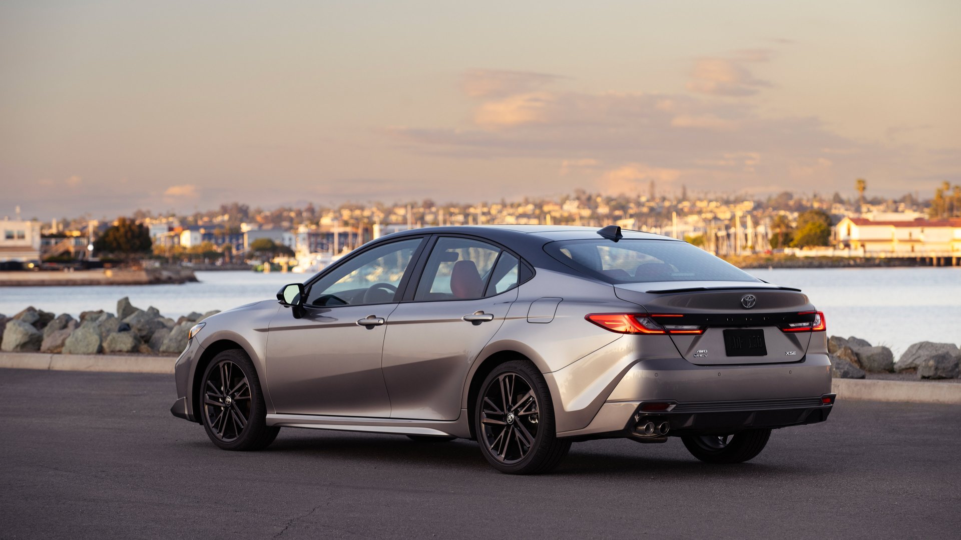HD desktop wallpaper featuring a Toyota Camry XSE parked by the waterfront during twilight, highlighting the car's sleek design and modern aesthetics.