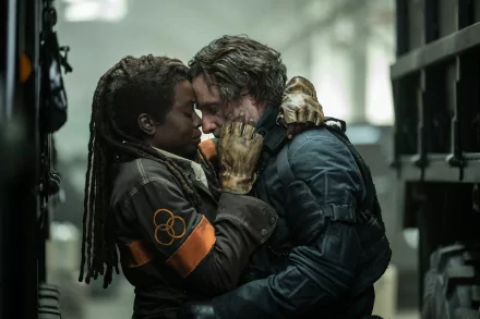 HD wallpaper from The Walking Dead: The Ones Who Live featuring two characters embracing amid chaotic surroundings.