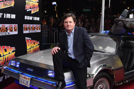 HD wallpaper of a person associated with Back To The Future leaning on a DeLorean, with movie branding in the background.