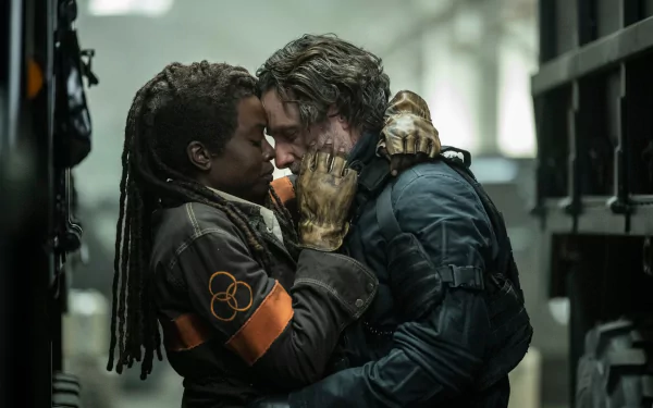 HD wallpaper from The Walking Dead: The Ones Who Live featuring two characters embracing amid chaotic surroundings.