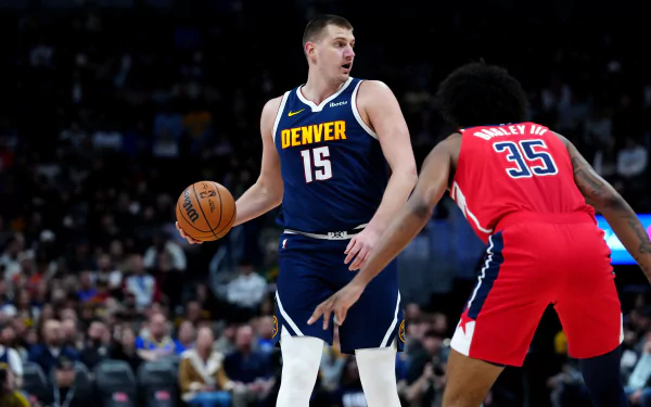 HD Denver Nuggets desktop wallpaper featuring the team's player in the iconic number 15 jersey poised with a basketball during an NBA game.