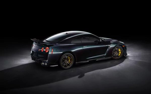 Nissan GT-R T-Spec Takumi Edition car showcased as a sleek HD desktop wallpaper and background, emphasizing its dark paint and distinctive gold wheels.