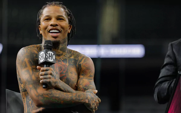 HD wallpaper featuring a boxer speaking into a microphone, with numerous tattoos visible on his arms and chest.