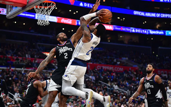 An HD desktop wallpaper featuring a Dallas Mavericks player executing a layup, with a defender from the opposing team close behind during an NBA basketball game.