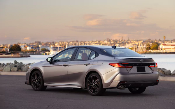 HD desktop wallpaper featuring a Toyota Camry XSE parked by the waterfront during twilight, highlighting the car's sleek design and modern aesthetics.