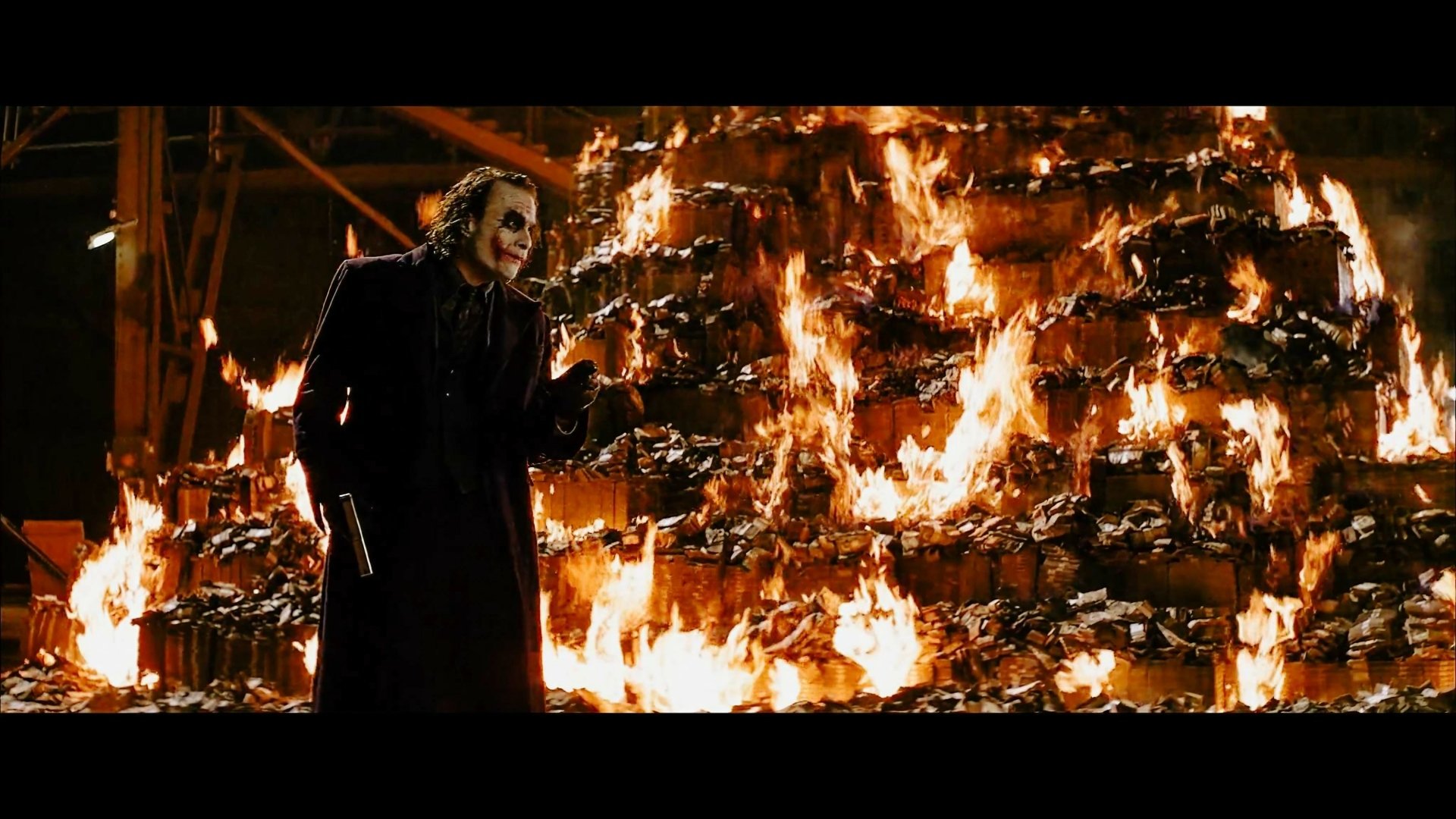 The Dark Knight’s Joker stands menacingly in front of a towering blaze, captured in this intense 4K Ultra HD PC desktop wallpaper.