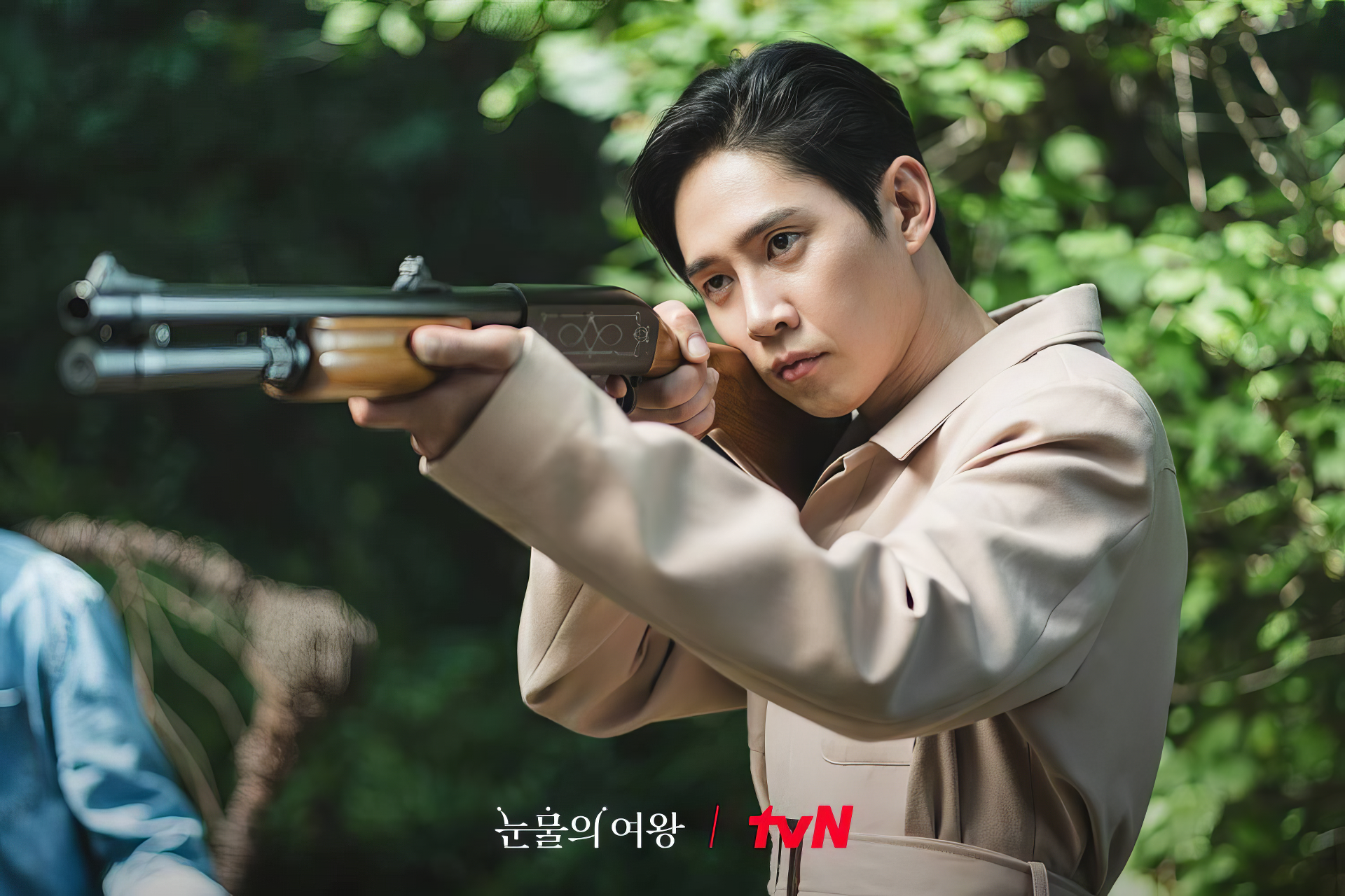 HD desktop wallpaper from the TV show Queen of Tears, featuring a man aiming a rifle in a forest scene, branded with the tvN logo.