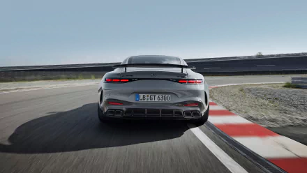 HD desktop wallpaper featuring the rear view of a sleek Mercedes-AMG GT63 PRO driving on a racetrack, highlighting its powerful design and speed against a clear sky.