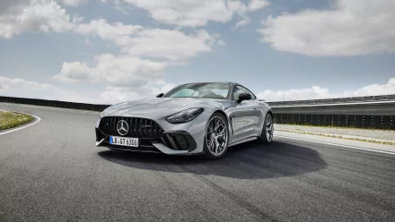 HD wallpaper featuring a sleek Mercedes-AMG GT63 PRO on a racetrack, showcasing its stylish design and performance capabilities against a scenic sky background.