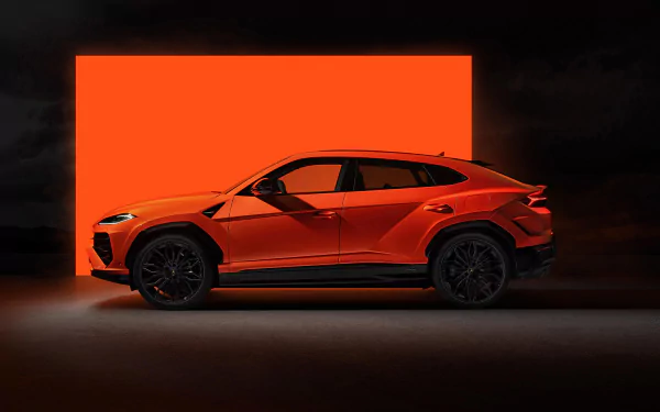 HD desktop wallpaper of a Lamborghini Urus in an eye-catching orange shade against a vivid red background, showcasing its sleek design and dynamic pose.