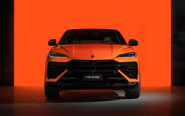 HD desktop wallpaper of a Lamborghini Urus displayed against an orange background, showcasing the front view of the sleek, orange sports car.