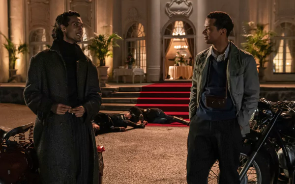 HD wallpaper from Interview with the Vampire featuring two characters conversing in front of an elegant building with motorcycles and bodies on the ground.