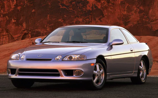 High-definition desktop wallpaper featuring a sleek Lexus SC400 car against a backdrop of rugged red rock formations.