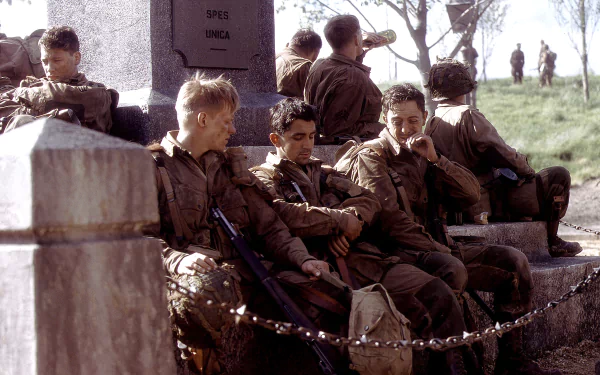 HD wallpaper featuring soldiers from the TV show Band of Brothers resting near a monument, capturing a moment of camaraderie and respite.