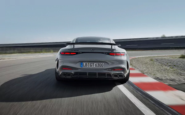 HD desktop wallpaper featuring the rear view of a sleek Mercedes-AMG GT63 PRO driving on a racetrack, highlighting its powerful design and speed against a clear sky.