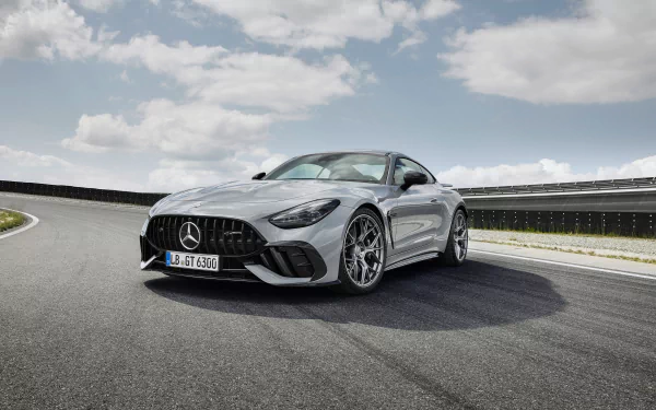 HD wallpaper featuring a sleek Mercedes-AMG GT63 PRO on a racetrack, showcasing its stylish design and performance capabilities against a scenic sky background.