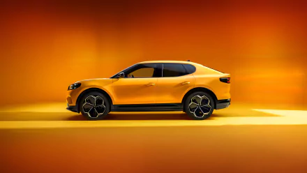 A striking Ford Capri in vibrant yellow, set against a warm orange backdrop, creates an eye-catching HD desktop wallpaper that captures the essence of dynamic automotive design.