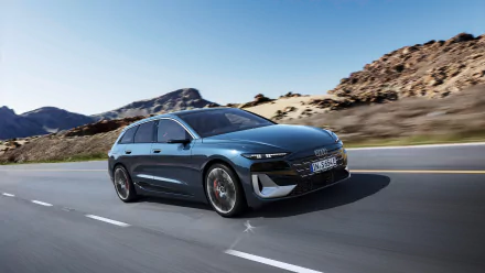 A sleek Audi S6 E-Tron drives along a winding road, framed by rugged mountains. This stunning image serves as an HD desktop wallpaper and background for car enthusiasts.