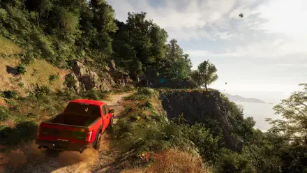 A vibrant scene from Test Drive Unlimited Solar Crown, featuring a red truck navigating a scenic, rugged path surrounded by lush greenery and a distant view of the ocean.