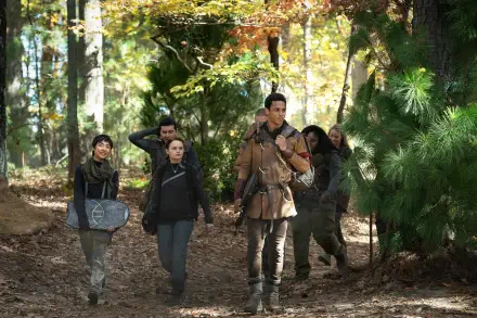 A group of young people walks through a forest, showcasing themes of rebellion and friendship from the movie Uglies. The scene captures the essence of adventure in vibrant autumn colors.