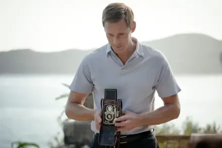 Alexander Skarsgård holding a vintage camera in a scene from the 2023 movie Lee, featured in a 4K Ultra HD PC desktop wallpaper and background.