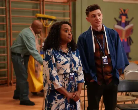 A scene from the TV show Abbott Elementary, featuring two characters in a school setting with staff members. The image serves as a vibrant HD desktop wallpaper.