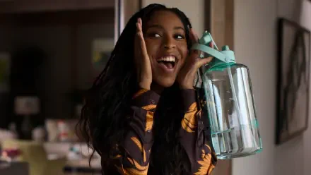 Jessica Williams joyfully poses with a water jug from the TV show Shrinking, in this vibrant 4K Ultra HD desktop wallpaper.