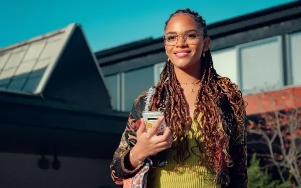 4K Ultra HD PC wallpaper featuring a smiling character from the TV show Heartstopper, holding a phone against a bright outdoor backdrop.