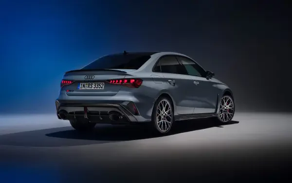 A stunning Audi RS3 Sedan showcases its sleek design against a dark, moody background, captured in vibrant 4K Ultra HD quality for an impressive desktop wallpaper.