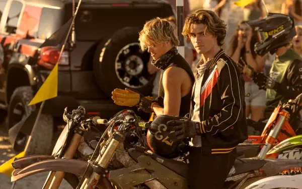 Chase Stokes and Rudy Pankow from the TV show Outer Banks pose on motorcycles, capturing a vibrant scene from the series in this HD desktop wallpaper.
