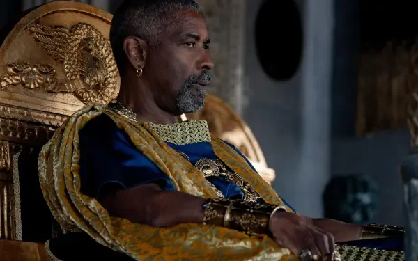 Denzel Washington sits majestically on a throne in this striking HD wallpaper from Gladiator II, showcasing a powerful scene from the film.
