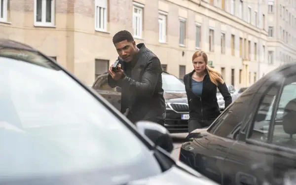 A tense moment from the TV show FBI: International, featuring agents navigating a city street, showcasing action and drama in a 4K Ultra HD desktop wallpaper.