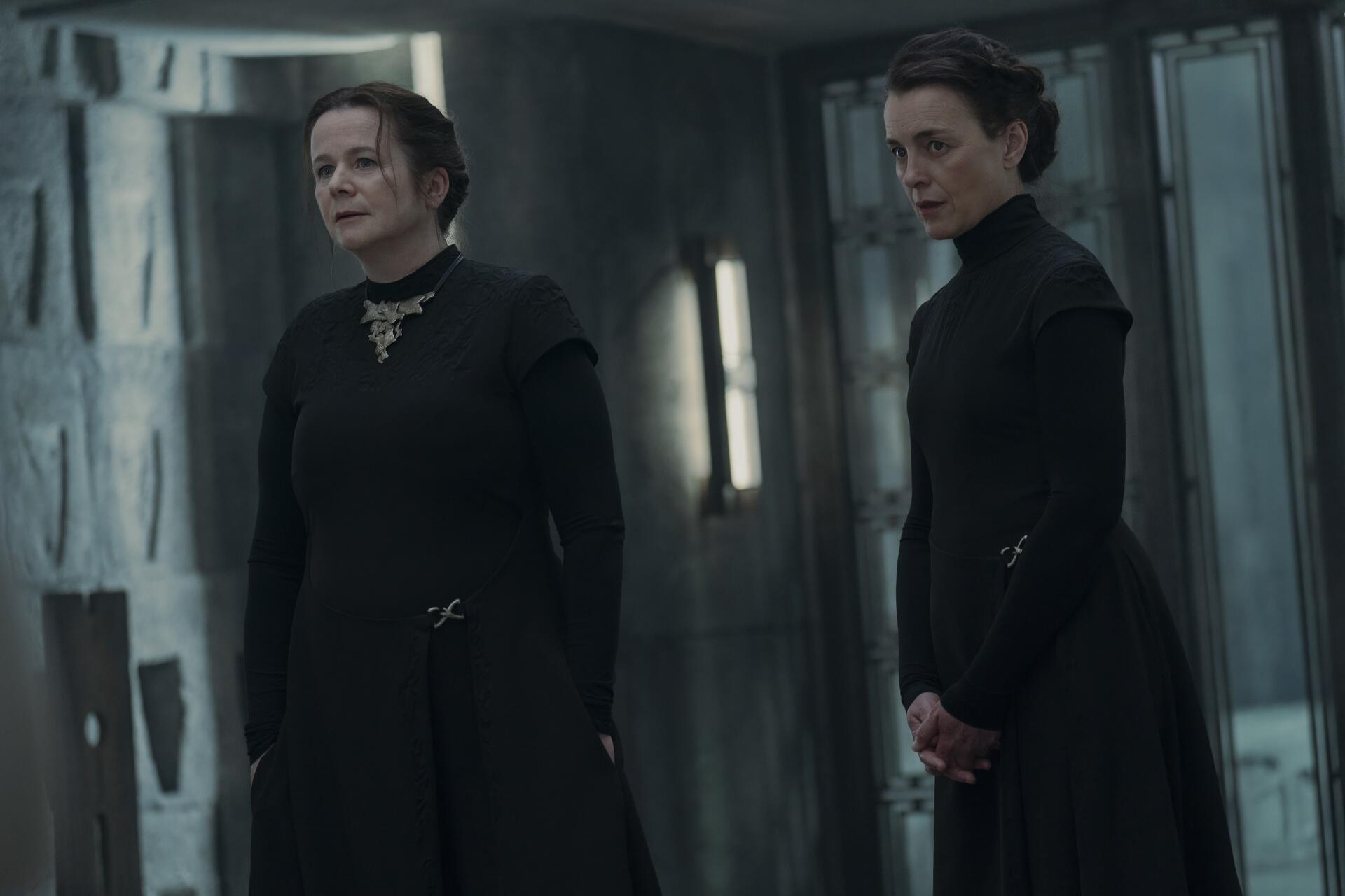 A scene from the TV show Dune Prophecy, featuring Emily Watson and another character in dark attire, set against a futuristic backdrop. High-definition wallpaper for desktop backgrounds.
