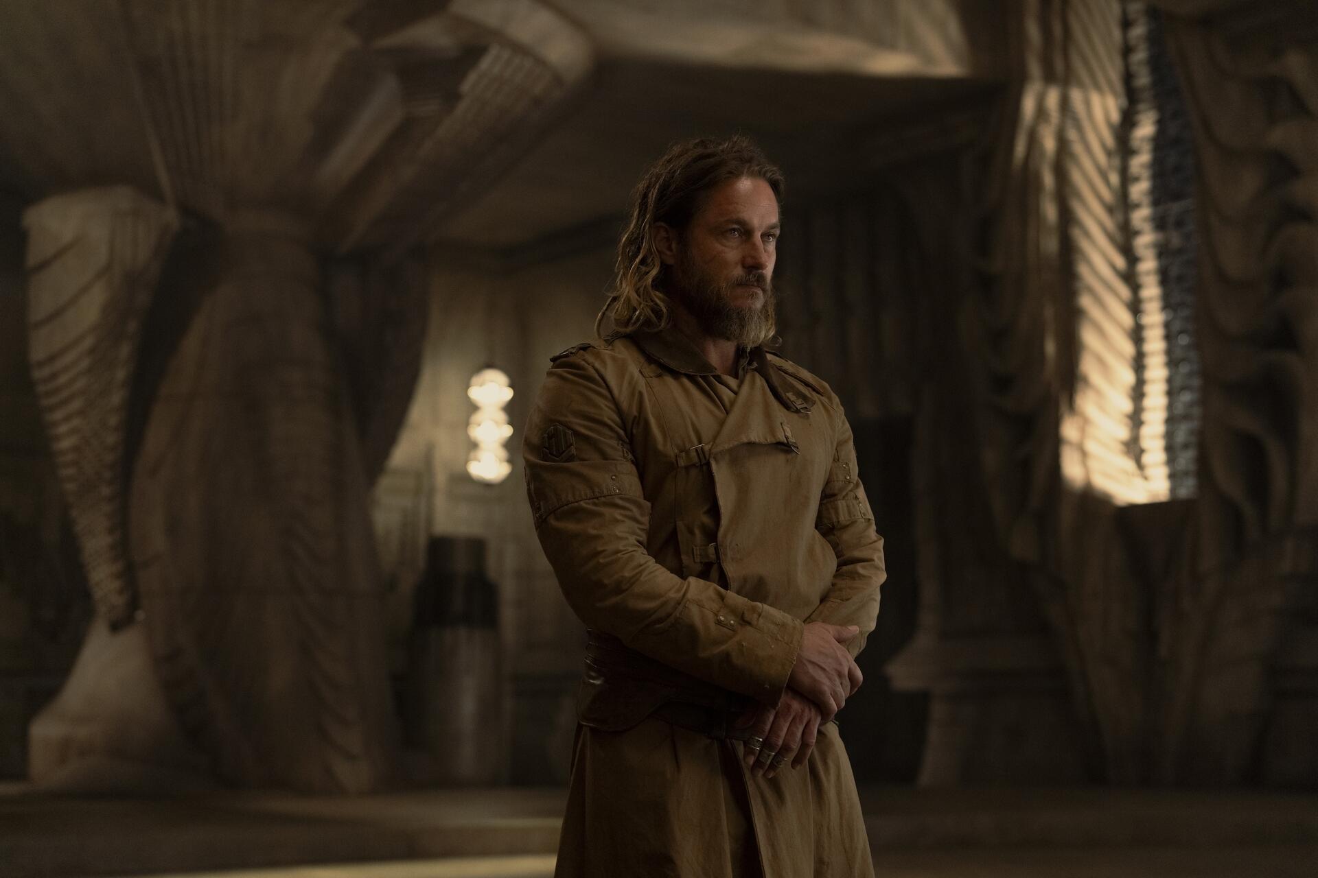 HD wallpaper featuring Travis Fimmel in the TV show Dune Prophecy, showcasing a dramatic scene with intricate background details.