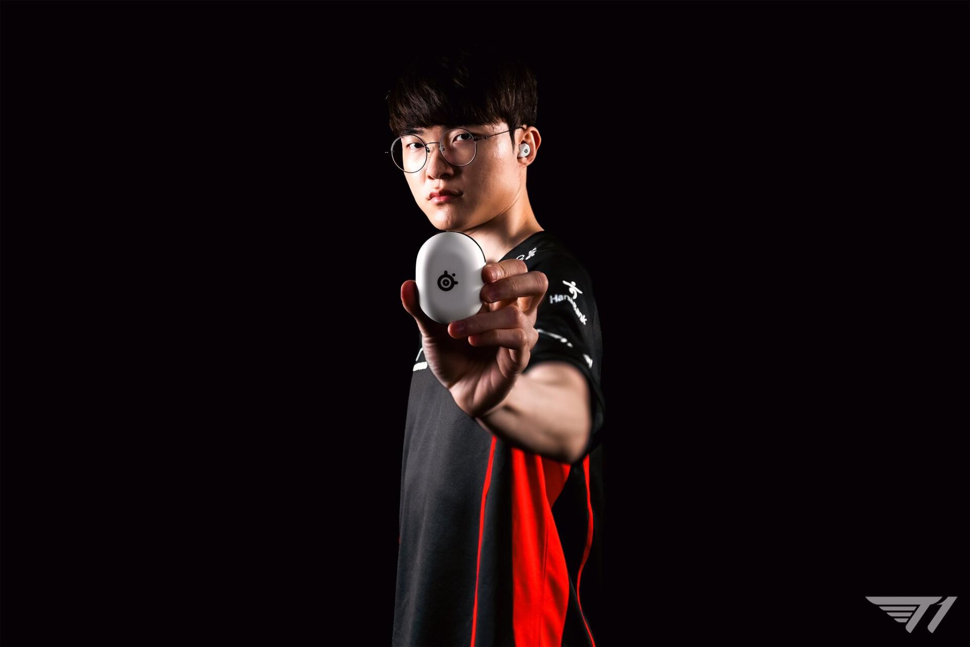 A high-definition esports wallpaper featuring T1's Faker, a prominent League of Legends player, gripping a gaming mouse against a dark background.