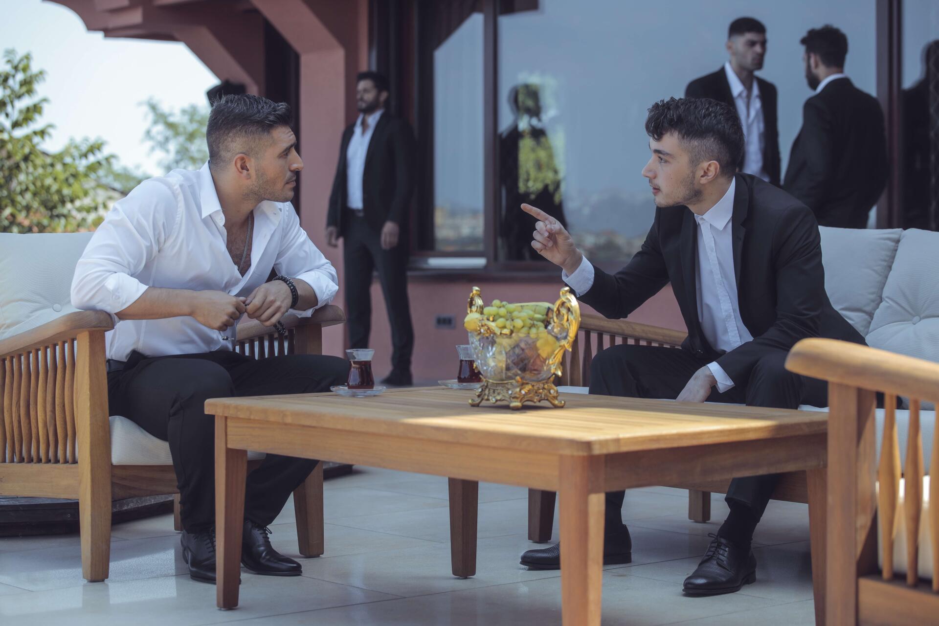 Scene from the TV show The Pit featuring two men in conversation at an outdoor seating area, captured in a 4K Ultra HD PC desktop wallpaper and background.