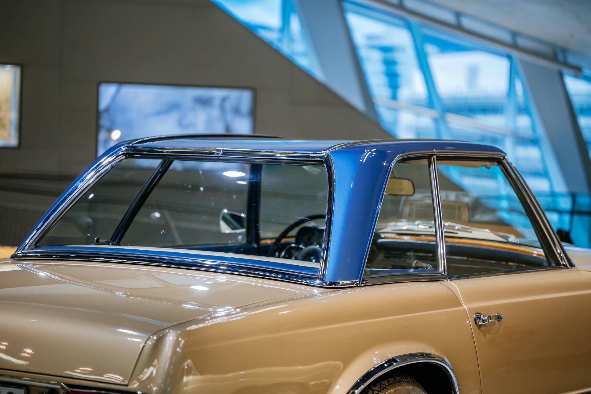 A close-up of a Mercedes-Benz 230 SL showcasing its classic design, featuring a distinctive blue hardtop and elegant lines, set against a modern background in this stunning 4K Ultra HD wallpaper.