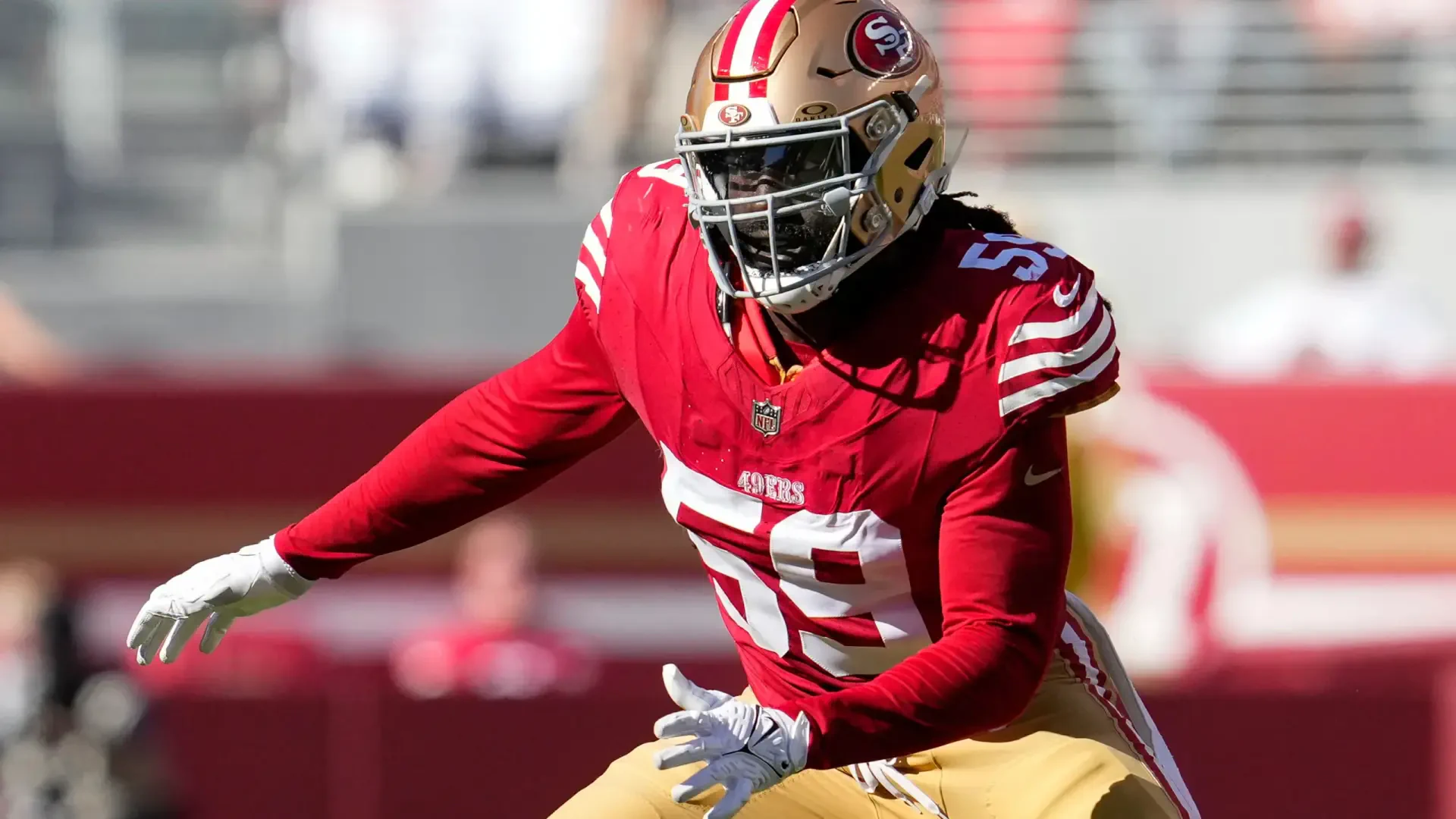 De'Vondre Campbell in action for the San Francisco 49ers, showcasing his athleticism in a vibrant red and gold uniform during an NFL game. A striking HD wallpaper for football fans.