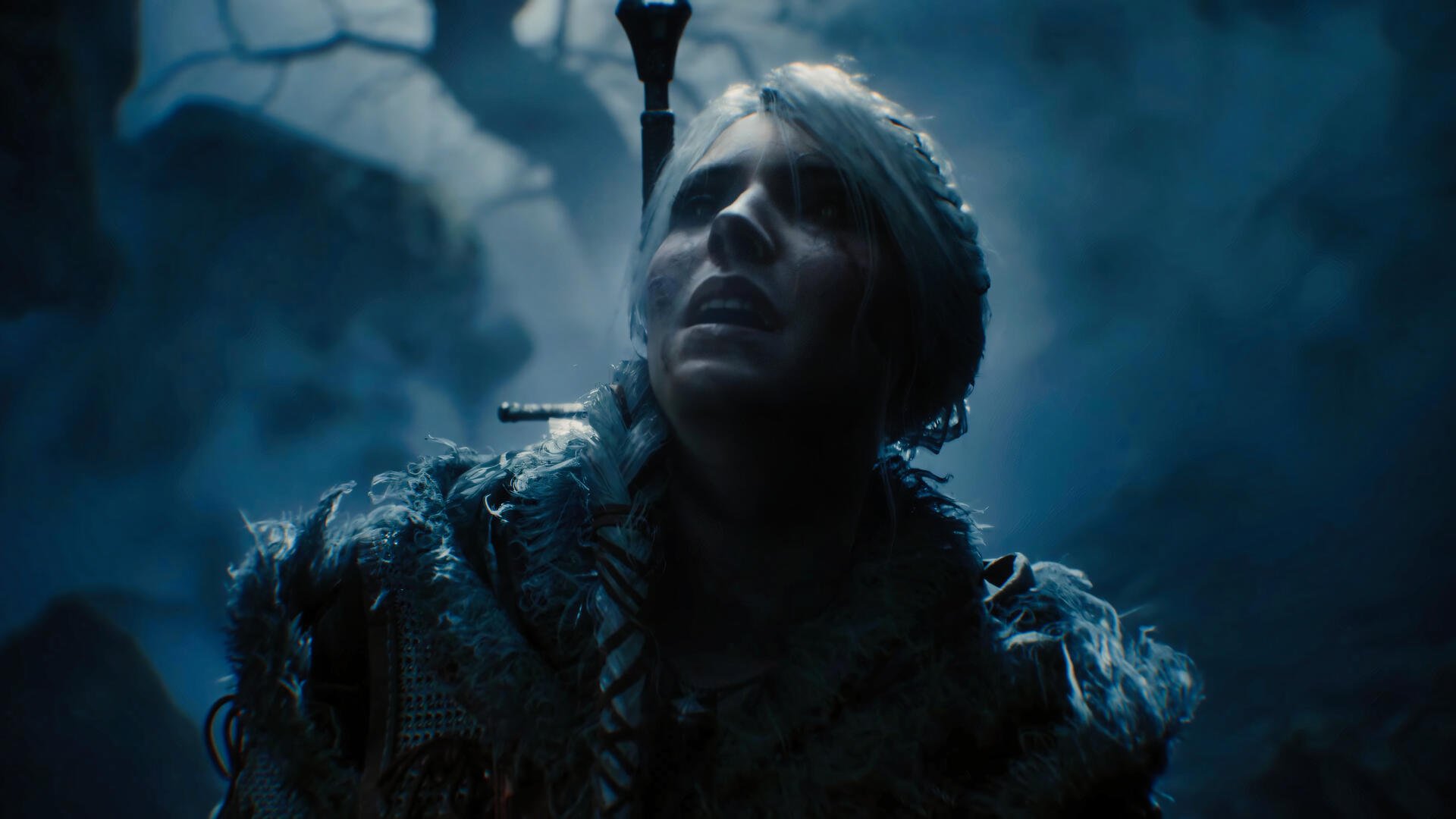 Ciri from The Witcher IV stands in a mystical, dark forest, looking upward, surrounded by ethereal mist. This captivating image serves as a 4K Ultra HD wallpaper for fans of the game.