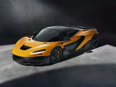 A striking McLaren W1 in vibrant orange and black, showcasing its aerodynamic design against a minimalist backdrop. This 8K Ultra HD image makes a bold statement for any desktop.